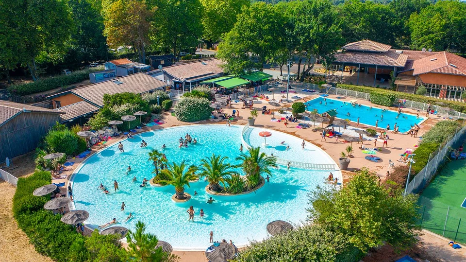 Round pool surrounded by palm trees at the Domaine de la Forge campsite
