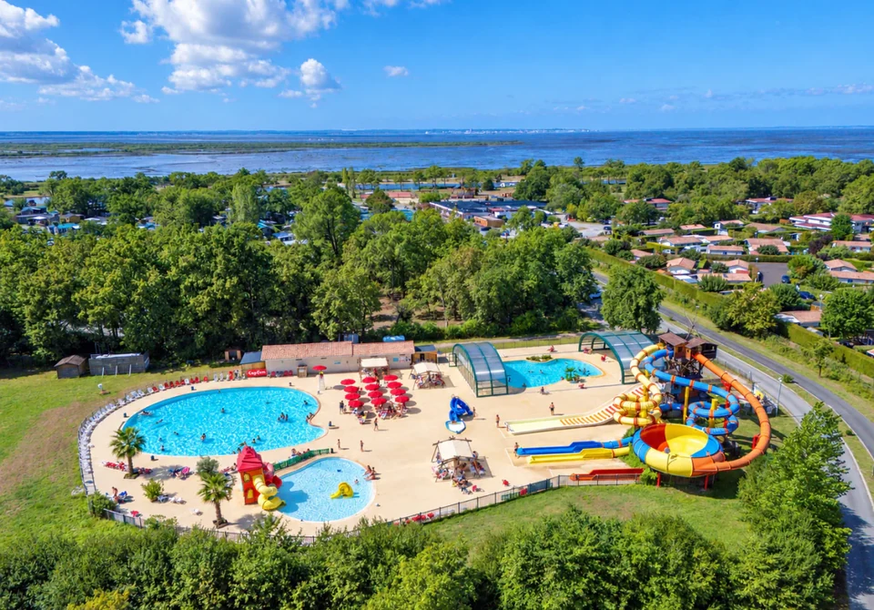 Aerial view of Camping Cap Fun, its pools, its water slides and the ocean in the distance